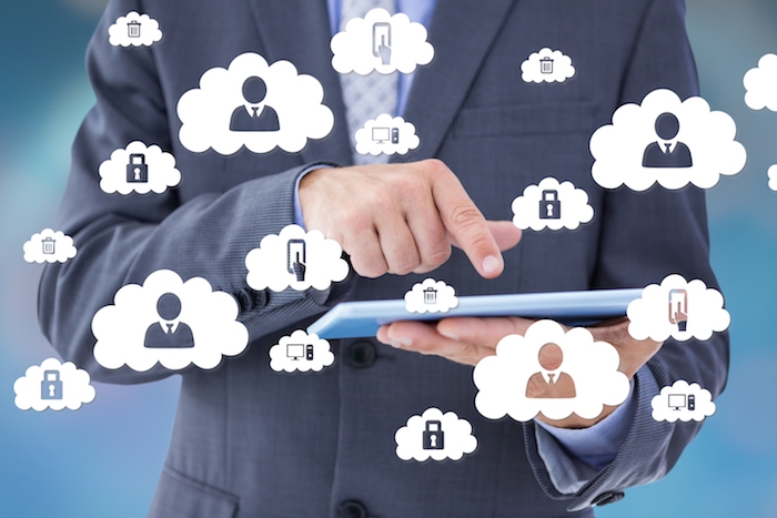 Composite image of businessman holding and using tablet computer